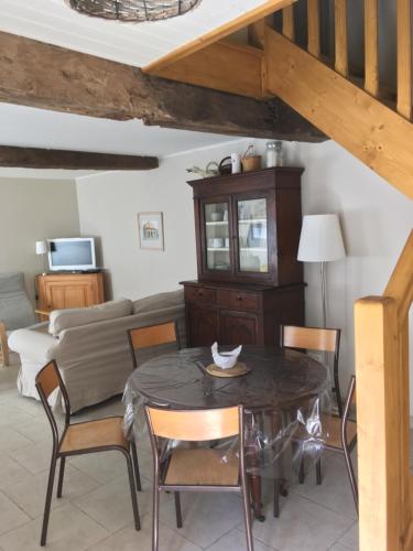 un salon avec une table, des chaises et un canapé dans l'établissement charmant gite LE PETIT LOGIS, à Issigeac