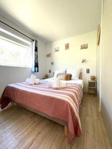 a bedroom with a large bed with a red blanket at Bungalow à la campagne in Riventosa