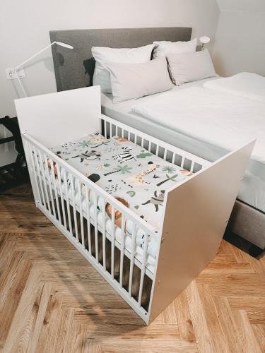 a white crib in a bedroom with a bed at DOM Apartment I - modern & zentral mit kostenfreiem Parkplatz in Fulda