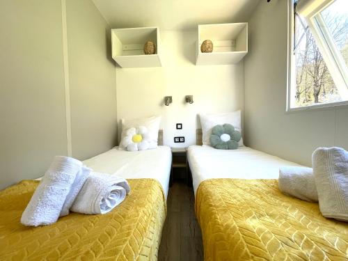 two twin beds in a room with a window at Bungalow à la campagne in Riventosa