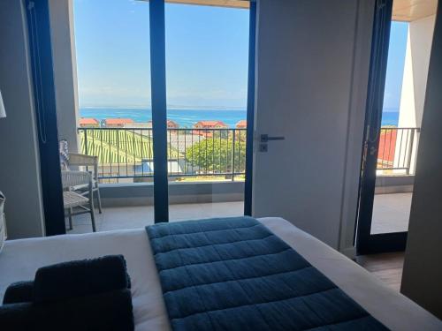 a bedroom with a bed and a view of a balcony at Perfect View 204 Mossel Cove in Mossel Bay