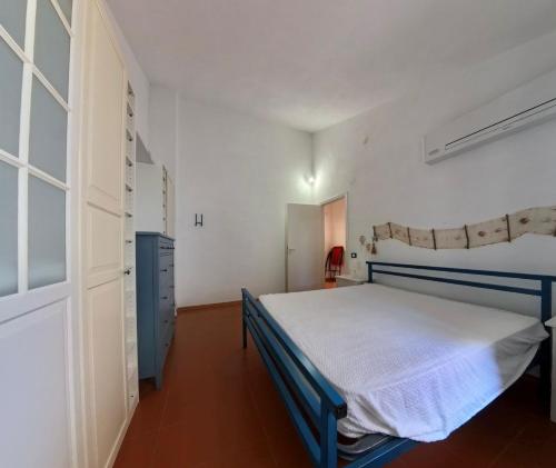 a bedroom with a blue bed in a white room at villa francesca e cristina in Ferruzzano