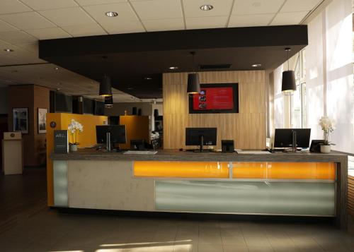 a lobby with a reception desk with computers on it at ibis Frankfurt Centrum in Frankfurt/Main