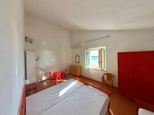 a bedroom with a bed and a red cabinet at villa francesca e cristina in Ferruzzano