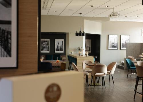 a restaurant with chairs and a table and a counter at ibis Frankfurt Centrum in Frankfurt/Main