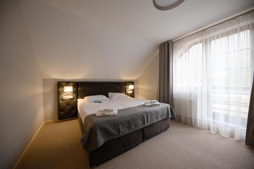 a bedroom with a bed and a large window at Voevodyno Resort in Tur'ya Pasika