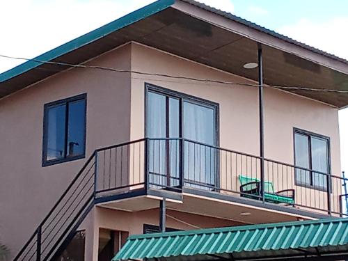 a house with a balcony with a bench on it at Cabina Hermanas Valencia in Monteverde Costa Rica