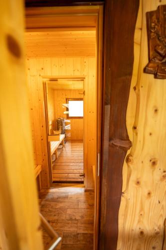 a hallway of a wooden cabin with a hallway leading into a room at Domek z kominkiem i jacuzzi in Łobozew