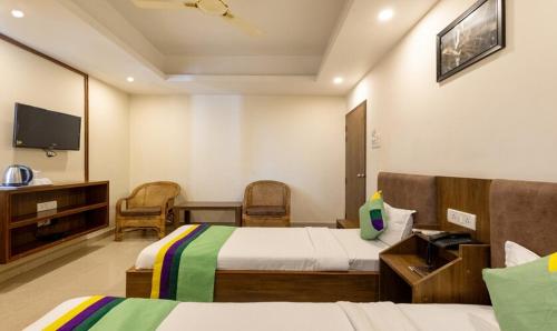 a hotel room with two beds and a tv at SWAGATAM INN, 5 minutes walk from Guwahati Railway Station in Guwahati