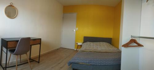 - une chambre avec un bureau, un lit et une table dans l'établissement Parenthèse salée en Côte d'Armor, à Saint-Brieuc