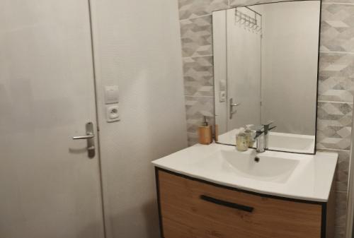 une salle de bain avec un lavabo et un miroir dans l'établissement Parenthèse salée en Côte d'Armor, à Saint-Brieuc