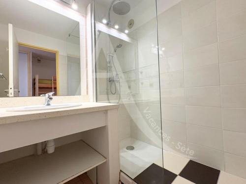 une salle de bain avec un lavabo et une douche dans l'établissement studio vue mer parking piscine tennis, à Sète