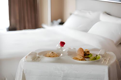 Una cama o camas en una habitación de Arul's Hotel