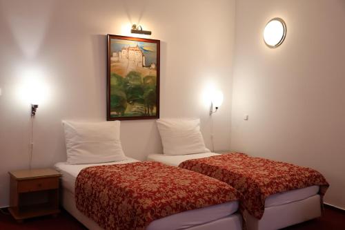 a hotel room with two beds and a painting on the wall at Unitas Residence in Prague