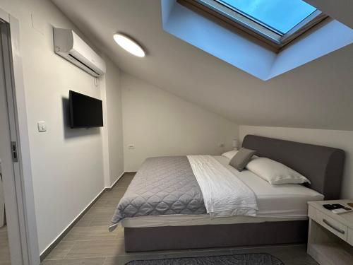 a bedroom with a large bed with a skylight at Luz del Mar in Kumbor