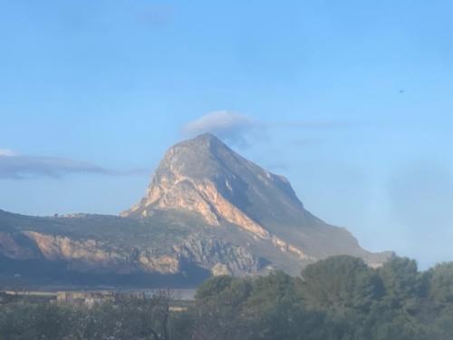 a mountain with smoke coming out of it at Cala di Ponente in Castelluzzo