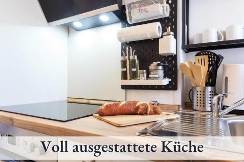 a kitchen counter with a loaf of meat on a cutting board at Relax-Apartment-One FN in Friedrichshafen