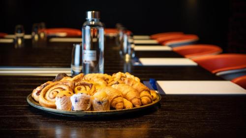 a plate of pastries on a table next to a piano at Holiday Inn Express & Suites Queenstown by IHG in Queenstown