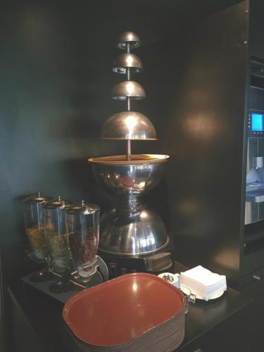 Brit Hotel Confort Nancy Lunéville في لونفيل: طاولة عليها مصباح وبعض الأكواب