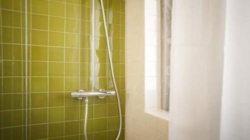 a shower with a hose in a green tiled bathroom at Maçãs Home-Land Sea View at The Beach in Colares