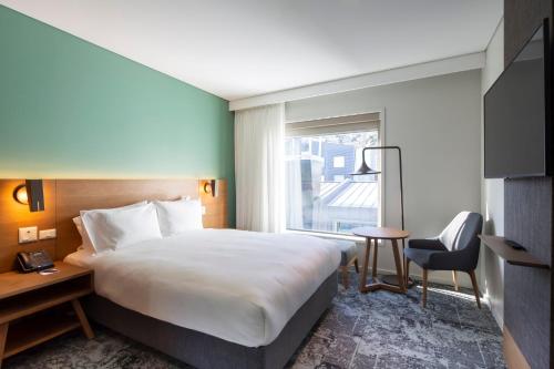 a hotel room with a large bed and a window at Holiday Inn Express & Suites Queenstown by IHG in Queenstown