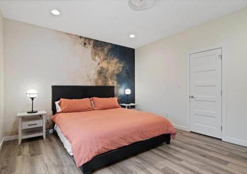 a bedroom with a bed with orange sheets and a wall at Winter @ Golden Goose: New Build, King Bed in Evansville