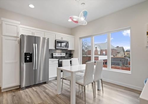 a kitchen with a table and a stainless steel refrigerator at Winter @ Golden Goose: New Build, King Bed in Evansville