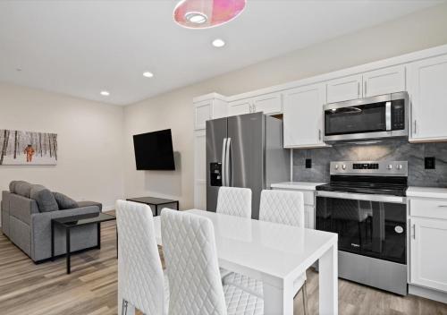 a white kitchen with a white table and chairs at Winter @ Golden Goose: New Build, King Bed in Evansville