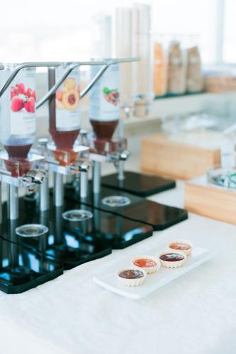 a coffee machine with cupcakes on a counter at Hotel Centrale Miramare in Rimini