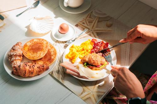 a table with a plate of breakfast food on it at Hotel Centrale Miramare in Rimini