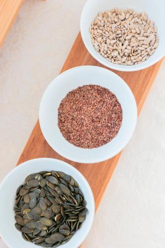 three bowls of seeds on a wooden cutting board at Hotel Centrale Miramare in Rimini