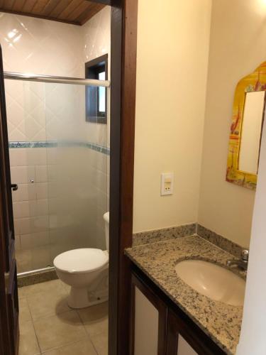 a bathroom with a toilet and a sink at Casa 6 Mares de Búzios - 5 minutos a pé da Rua das Pedras in Búzios