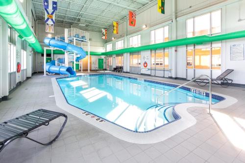a large swimming pool with a slide in a building at Holiday Inn Hinton by IHG in Hinton