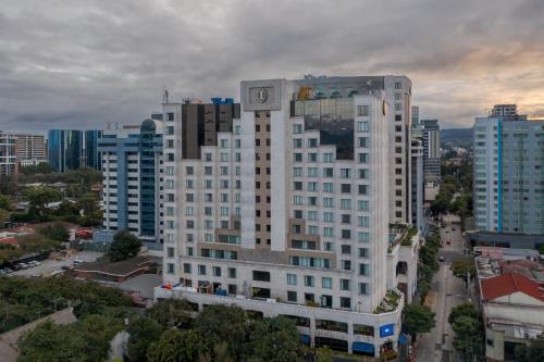 a large white building with a clock on it in a city at Intercontinental Real Guatemala by IHG in Guatemala