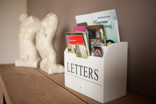 a white book stand on a table with books at Bed & Breakfast de Bimd Hoeve in De Bus
