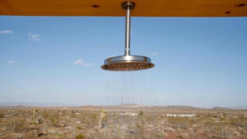 a ceiling fan with a view of the desert at Secluded-jt-spa-pool-firepit-sauna-game Room! in Yucca Valley