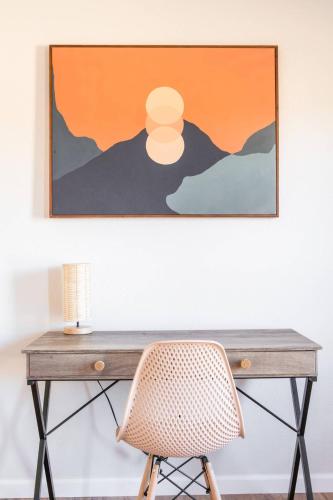 a desk with a chair and a picture on the wall at Secluded-jt-spa-pool-firepit-sauna-game Room! in Yucca Valley