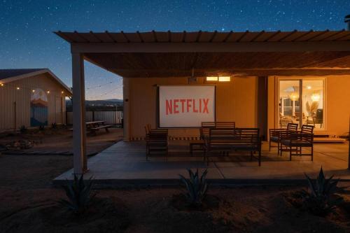 a netflix sign on the side of a building at night at Secluded-jt-spa-pool-firepit-sauna-game Room! in Yucca Valley