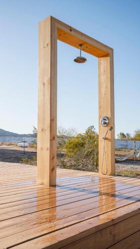 a wooden deck with a shower on the beach at Secluded-jt-spa-pool-firepit-sauna-game Room! in Yucca Valley