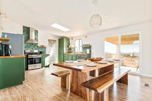 a kitchen with a wooden table and green cabinets at Secluded-jt-spa-pool-firepit-sauna-game Room! in Yucca Valley