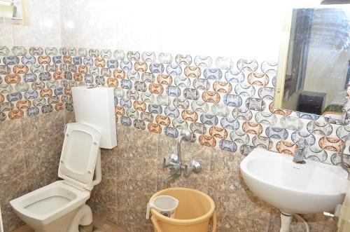 a bathroom with a toilet and a sink at Amutham Inn in Chennai
