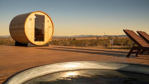 a wooden deck with a circular building with a pool at Secluded-jt-spa-pool-firepit-sauna-game Room! in Yucca Valley