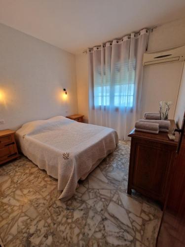 une chambre avec un grand lit et une fenêtre dans l'établissement Chez Maryse, à Hyères