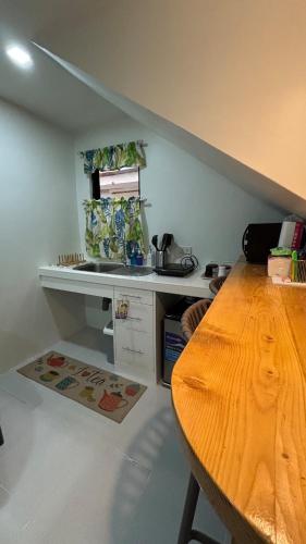 a kitchen with a counter and a wooden table at The Nest- Your home when you roam in Dumaguete in Dumaguete