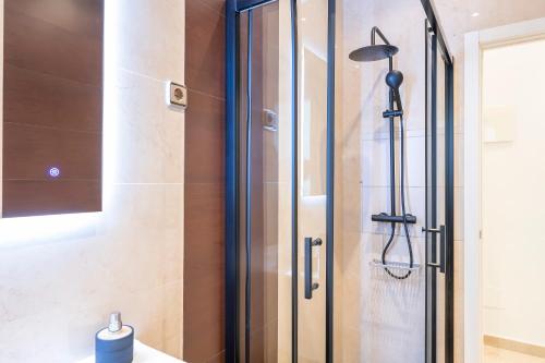 een douche met een glazen deur in een badkamer bij Exclusivo apartamento en el centro by beBalmy in Madrid
