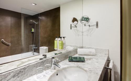 a bathroom with a sink and a large mirror at Sercotel Amister Art Hotel Barcelona in Barcelona