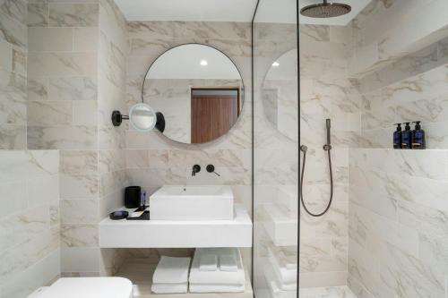 a bathroom with a sink and a mirror at Cardo Roma, Autograph Collection in Rome