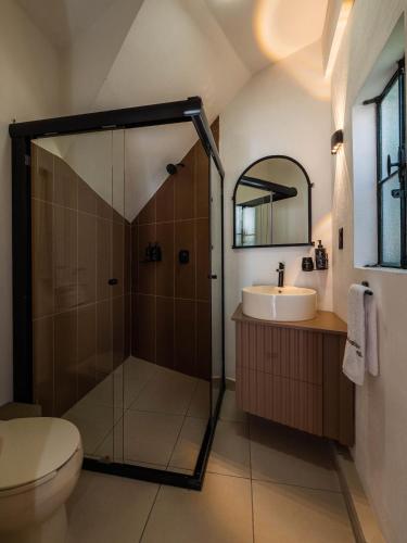 a bathroom with a shower and a toilet and a sink at Hotel Casa Domínguez in Taxco de Alarcón