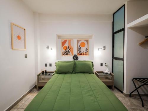 a bedroom with a large green bed in a room at Hotel Casa Domínguez in Taxco de Alarcón