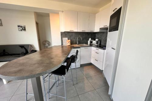 - une cuisine avec une table et deux chaises dans l'établissement Les pieds dans le sable Appartement Vue Mer 1 chambre 1 cabine, au Grau-du-Roi